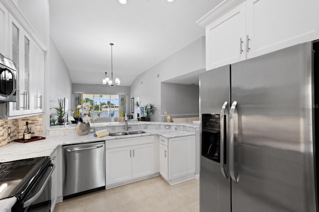 kitchen with sink, white cabinetry, vaulted ceiling, stainless steel appliances, and decorative backsplash