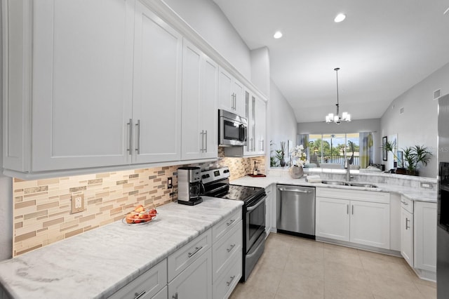 kitchen featuring vaulted ceiling, appliances with stainless steel finishes, sink, and white cabinets