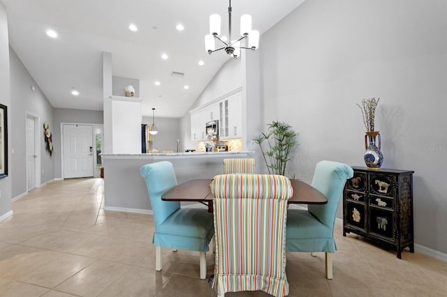 dining area featuring light tile patterned flooring, high vaulted ceiling, and a notable chandelier