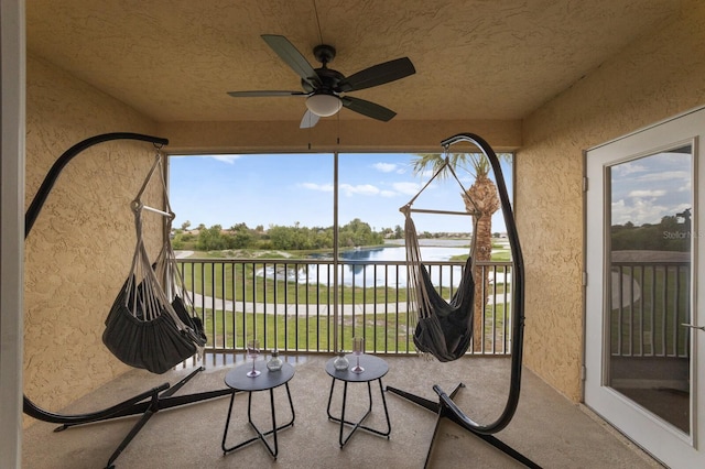 sunroom / solarium with a water view and ceiling fan