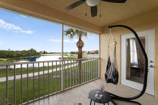 balcony featuring a water view and ceiling fan