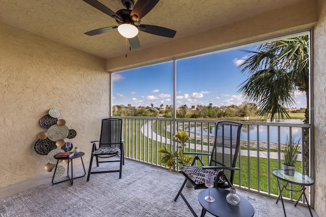 sunroom featuring a water view, a wealth of natural light, and ceiling fan