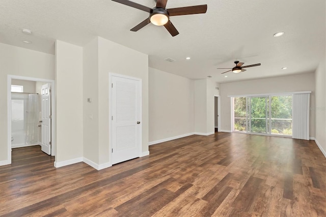 empty room featuring dark wood-type flooring, a textured ceiling, and ceiling fan