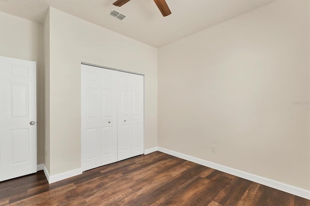 unfurnished bedroom with dark wood-type flooring, ceiling fan, and a closet