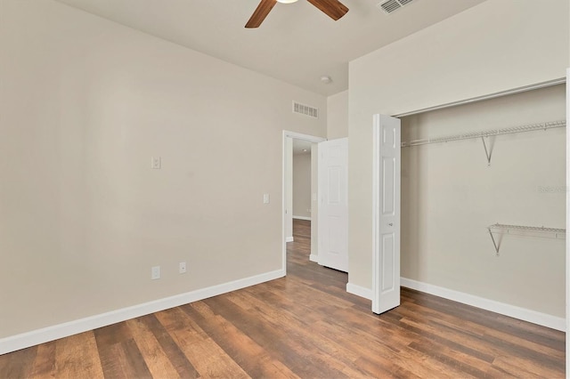 unfurnished bedroom with dark wood-type flooring, a closet, and ceiling fan