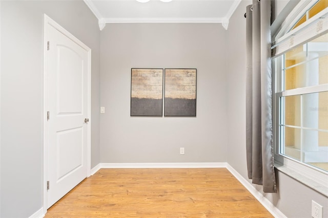 empty room featuring plenty of natural light, light hardwood / wood-style floors, and ornamental molding