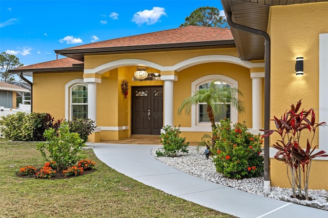 entrance to property featuring a lawn