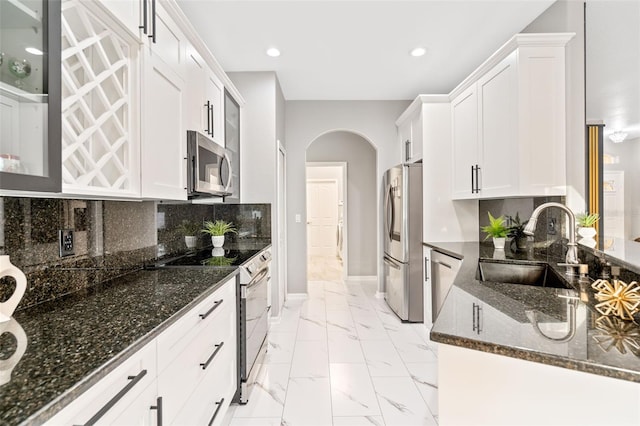 kitchen featuring white cabinets, decorative backsplash, sink, and appliances with stainless steel finishes