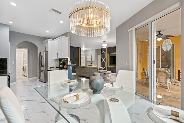 dining room with separate washer and dryer, sink, and ceiling fan with notable chandelier