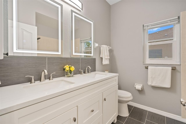 bathroom with vanity, backsplash, toilet, and a healthy amount of sunlight