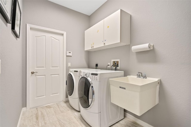 washroom featuring cabinets, independent washer and dryer, and sink