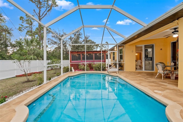 view of swimming pool with a sunroom, ceiling fan, a patio area, and a lanai