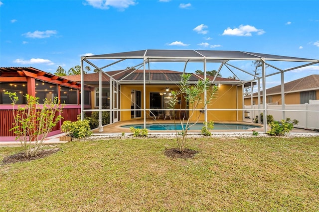 rear view of property featuring a lanai and a yard