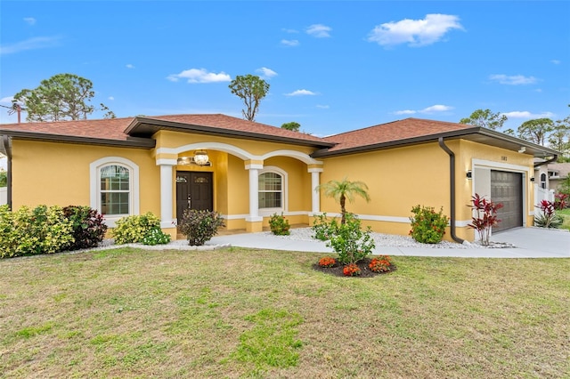 mediterranean / spanish house featuring a garage and a front lawn