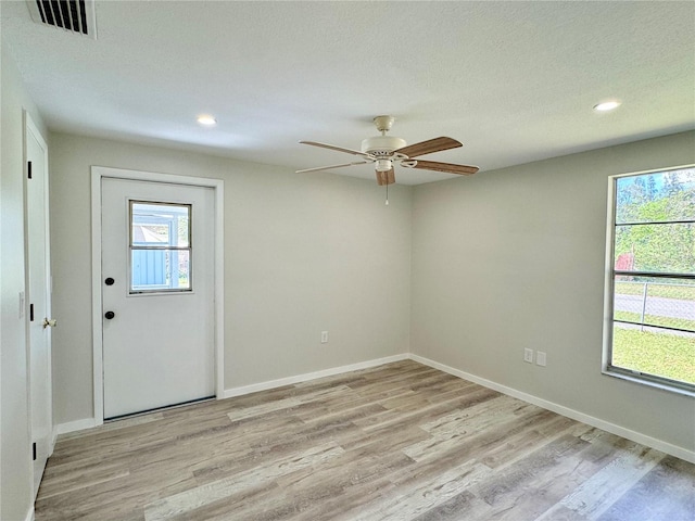 entrance foyer with light hardwood / wood-style floors, a textured ceiling, and ceiling fan