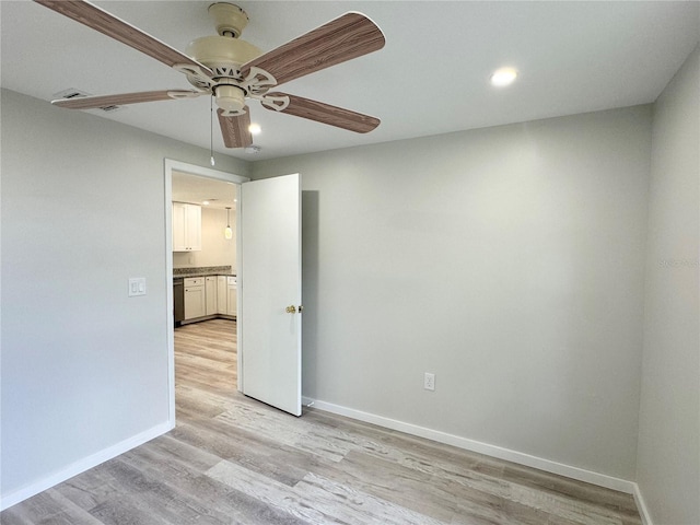 spare room with light hardwood / wood-style flooring and ceiling fan