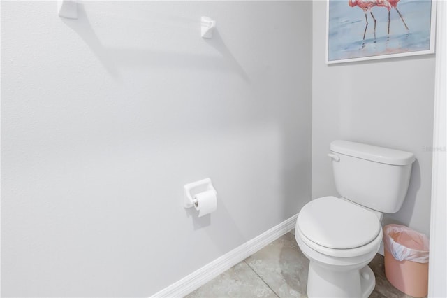 bathroom with toilet and baseboards