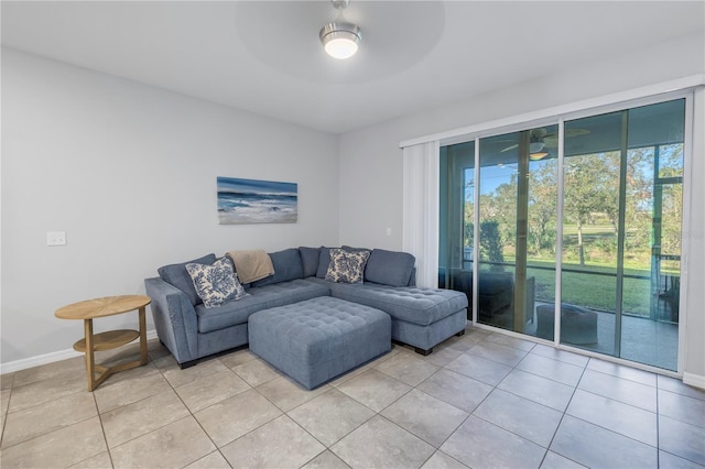 living room with ceiling fan, light tile patterned floors, and baseboards