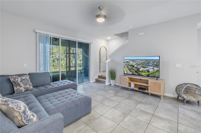 living room with light tile patterned floors, ceiling fan, and baseboards