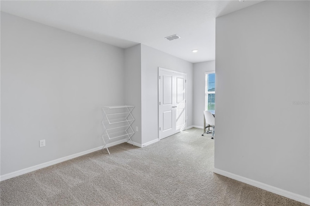 empty room featuring carpet floors, visible vents, and baseboards