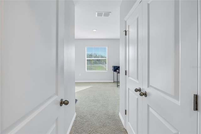 hall with light colored carpet