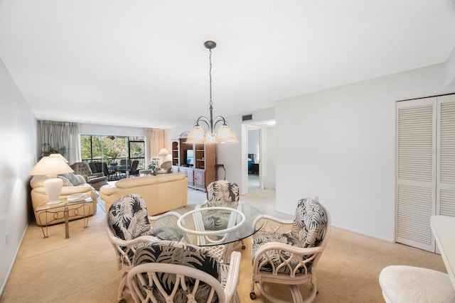 dining room with light colored carpet and a chandelier