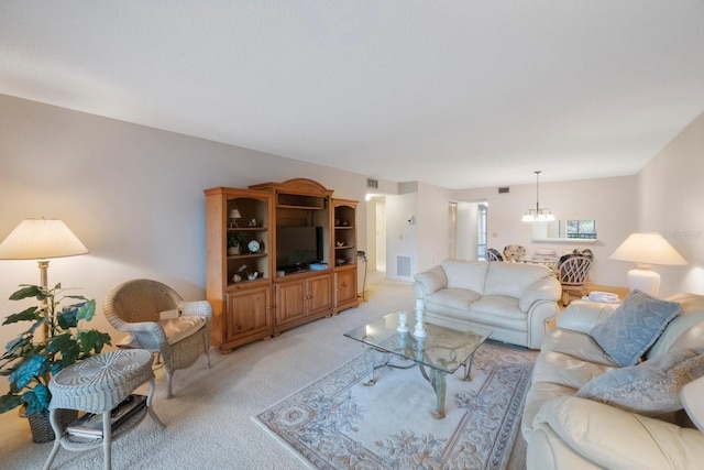 carpeted living room with a chandelier