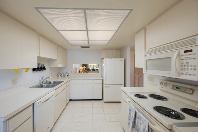 kitchen with white cabinets, sink, light tile patterned floors, and white appliances