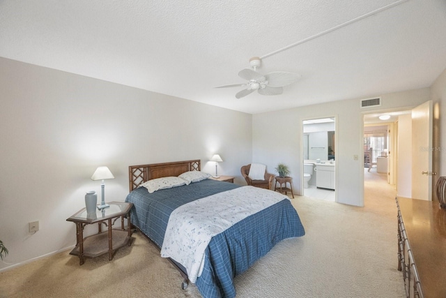 bedroom with connected bathroom, light carpet, a textured ceiling, and ceiling fan