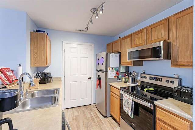 kitchen featuring sink, light hardwood / wood-style flooring, and stainless steel appliances