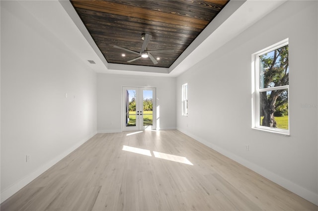 unfurnished room with french doors, light hardwood / wood-style flooring, a raised ceiling, and wood ceiling