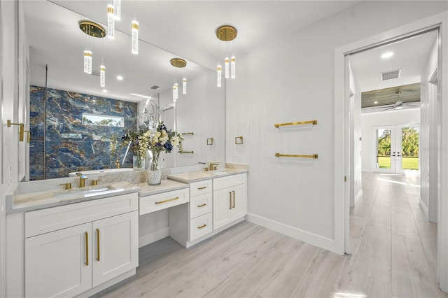 bathroom with hardwood / wood-style floors, vanity, and french doors