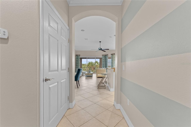 corridor featuring light tile patterned floors and ornamental molding