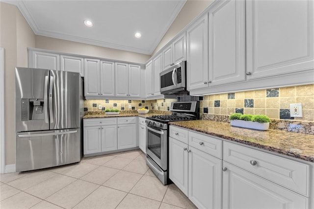 kitchen with appliances with stainless steel finishes, light stone countertops, light tile patterned floors, crown molding, and white cabinets