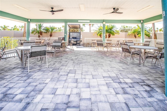 view of patio with ceiling fan and a tiled fireplace