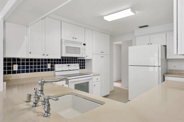 kitchen with white appliances, backsplash, sink, and white cabinets