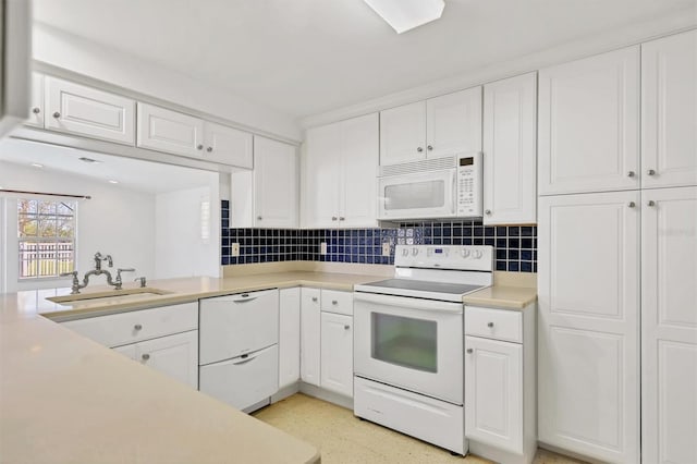 kitchen featuring decorative backsplash, white cabinets, sink, and white appliances