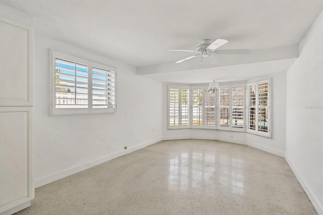 spare room with ceiling fan and plenty of natural light