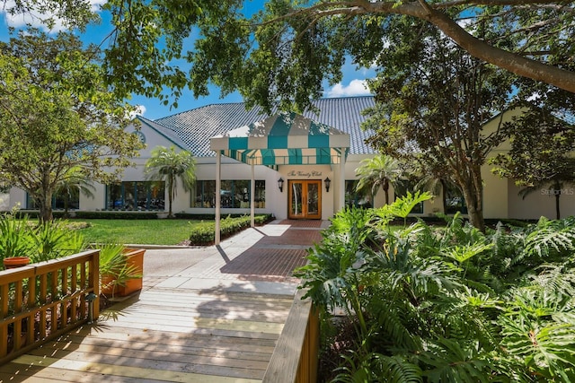 rear view of house featuring a lawn and french doors