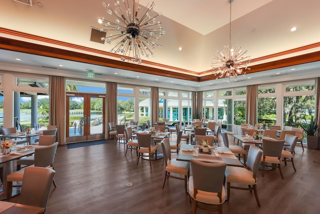 dining room featuring a high ceiling, french doors, crown molding, dark hardwood / wood-style flooring, and a chandelier