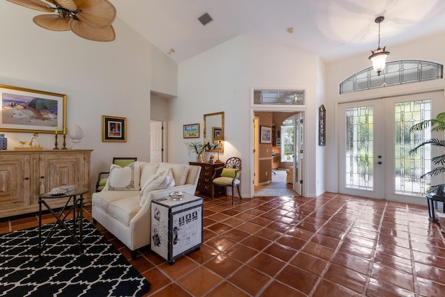 foyer with french doors, high vaulted ceiling, dark tile patterned flooring, and ceiling fan