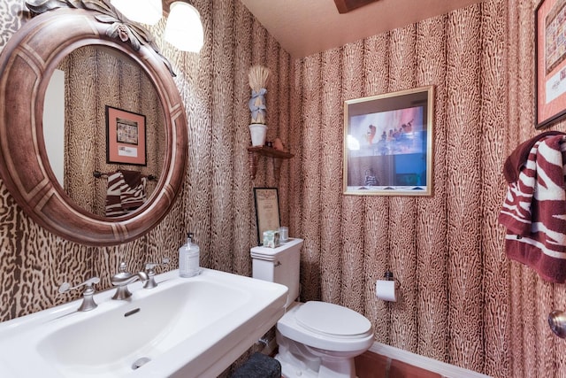 8223 Regents Ct, University Park, FL 34201 - half bath featuring wallpapered walls, a sink, and toilet