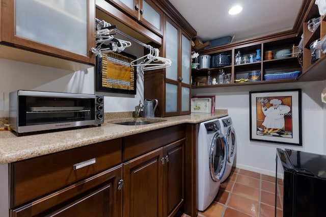 laundry room featuring washing machine and clothes dryer, a sink, tile patterned flooring, and a toaster