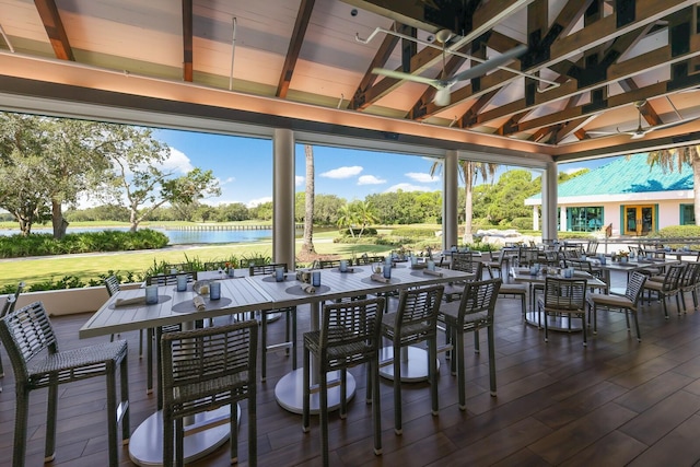 sunroom featuring a water view and beam ceiling