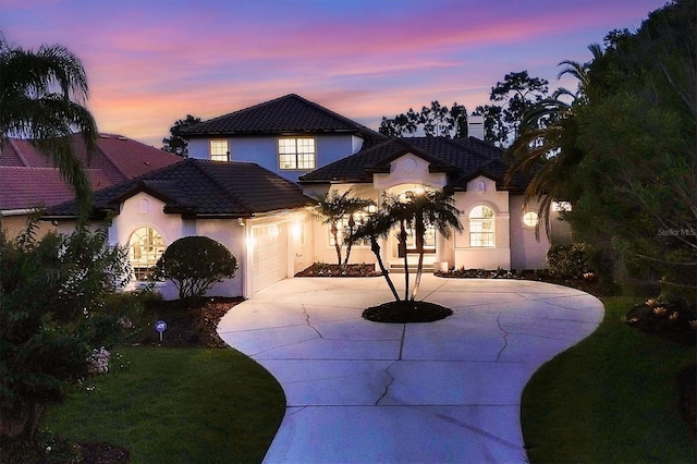 view of front of house featuring a garage and a lawn