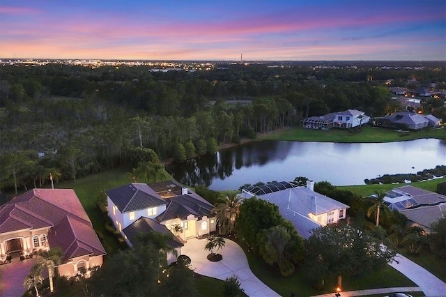 aerial view at dusk featuring a water view