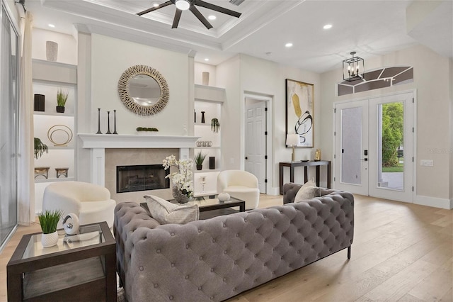 living room with light hardwood / wood-style floors, ornamental molding, and a chandelier