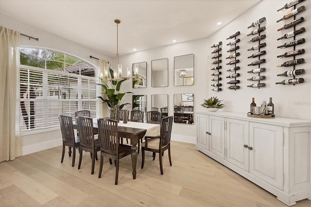 dining space featuring an inviting chandelier and light hardwood / wood-style floors