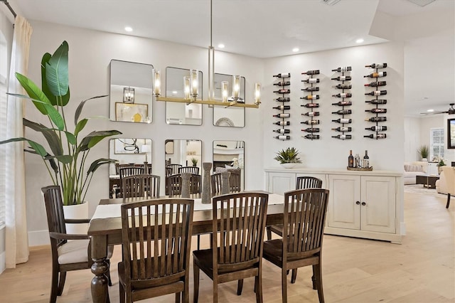 dining space with a notable chandelier and light wood-type flooring