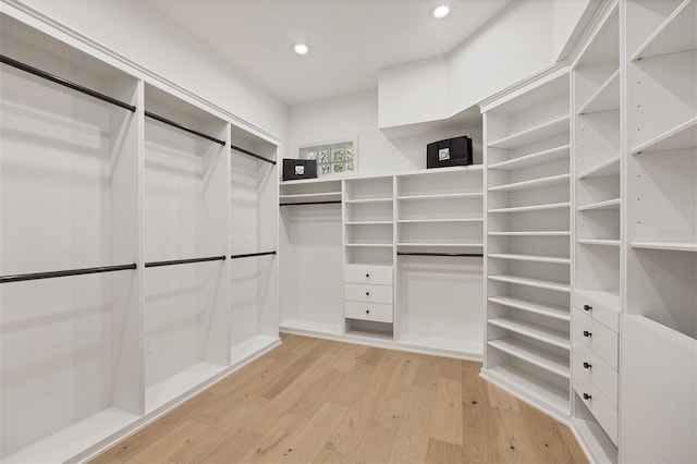 walk in closet with light hardwood / wood-style floors